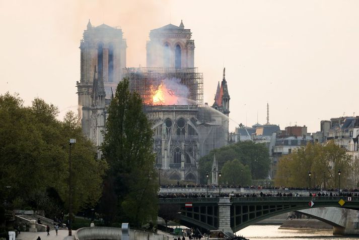 Slökkviliðsmenn slökkva eldinn með vatnsslöngum í Notre Dame í gær.