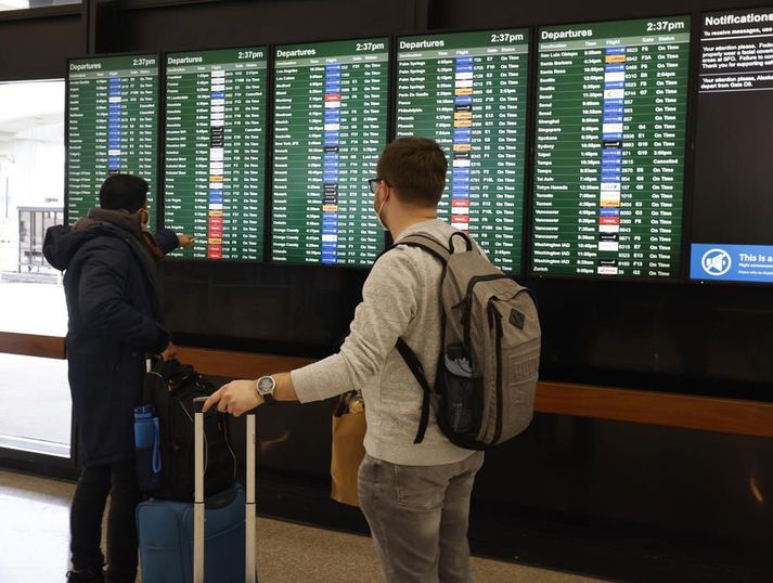 Ferðamenn fylgjast með stöðu mála á brottfaratöflunni á alþjóðaflugvellinum í San Francisco. Yfir 200 flugferðum innanlands var aflýst í Bandaríkjunum á aðfangadag.