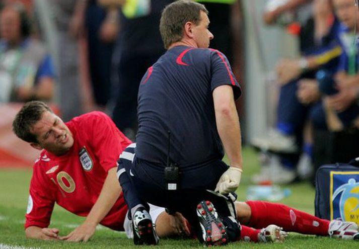 Michael Owen liggur hér sárþjáður eftir að hafa slitið krossbönd gegn Svíum.