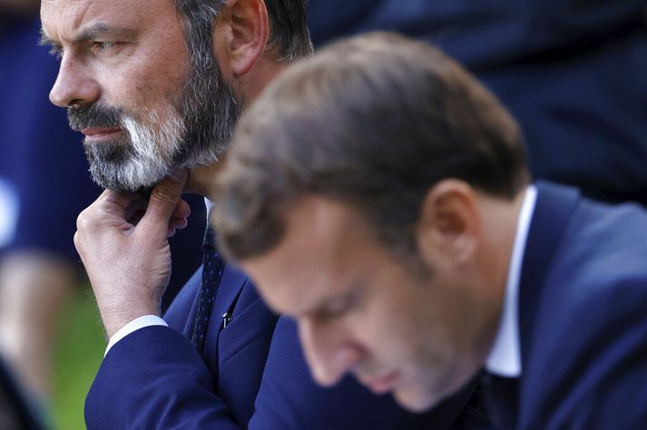 Emmanuel Macron Frakklandsforseti í forgrunni og  Edouard Philippe fráfarandi forsætisráðherra strýkur í gegnum skeggið. 