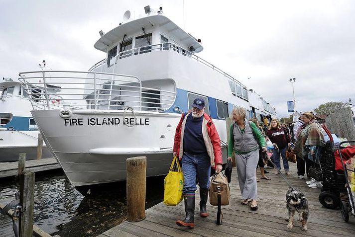 Íbúar á Fire Island við strendur New York ganga á brott úr ferju sem flutti þau frá heimkynnum sínum í gær. fréttablaðið/AP