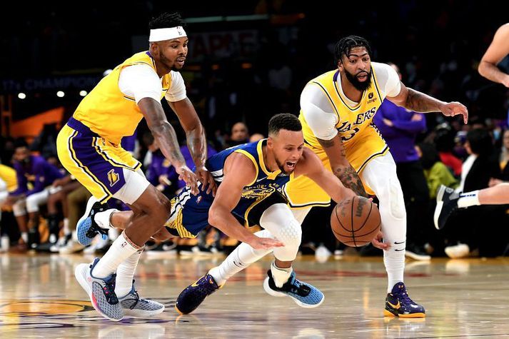Stephen Curry er hér kominn framhjá Lakers mönnunum Anthony Davis og Kent Bazemore í sigri Golden State Warriors á Los Angeles Lakers í nótt.
