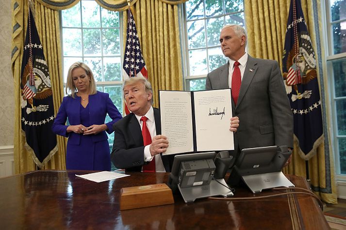 Donald Trump við undirritun tilskipunarinnar í kvöld, ásamt Kristjen Nielsen heimavarnaráðherra Bandaríkjanna og Mike Pence varaforseta.