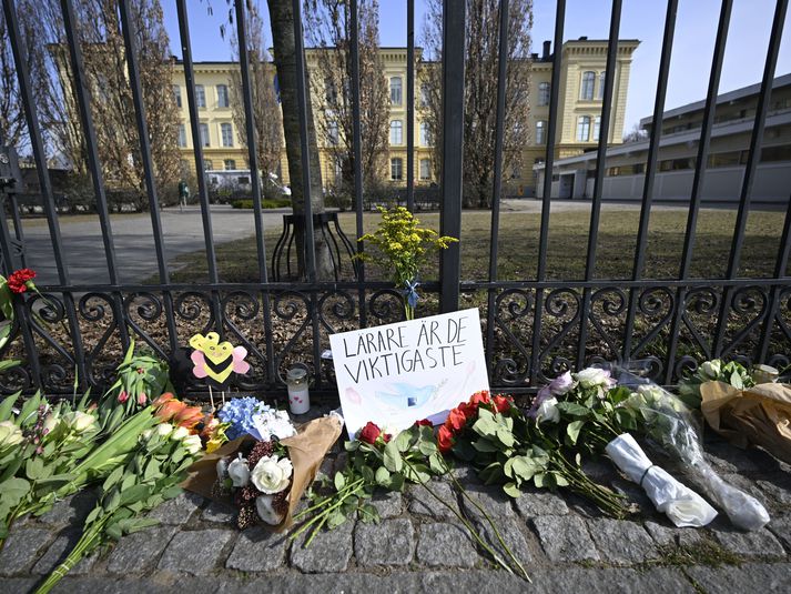 Blómvendir hafa verið lagðir utan við hlið Malmö Latin skólans þar sem 18 ára árásarmaður myrti tvo kennara skólans á mánudaginn.