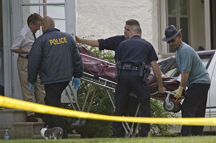 Lögreglumenn bera lík út úr húsinu í Delavan í gær.