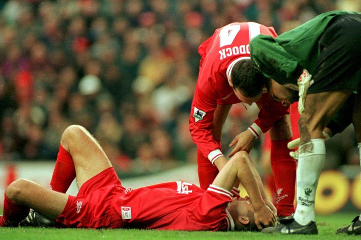 Dominic Matteo liggur hér meiddur í grasinu í leik með Liverpool en hann vissi ekki að æxli væri að vaxa í heila hans frá því að hann var barn.
