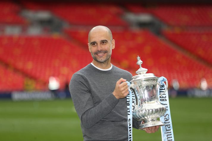 Guardiola með einn af mörgum bikurum sem hann hefur unnið með City.