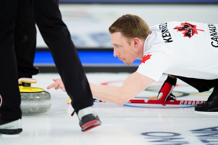 Kanadíski krullarinn Marc Kennedy sést hér pota í steininn í krullukeppni Vetrarólympíuleikanna.