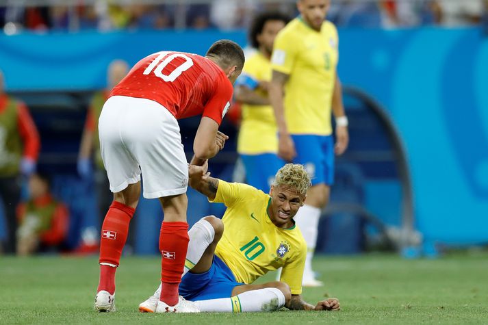 Neymar liggur óvígur eftir í leiknum á sunnudag. Sviss tók vel á móti Neymar.