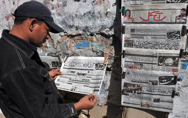 Fréttin vekur athygli í Pakistan Íbúi í Karachi les fréttir af handtöku Baradans.Nordicphotos/AFP