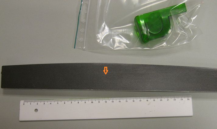 Búnaðurinn sem um ræðir. Rauða örin bendir á myndavélaop búnaðarins, en það er ekki stærra en blýantsoddur.