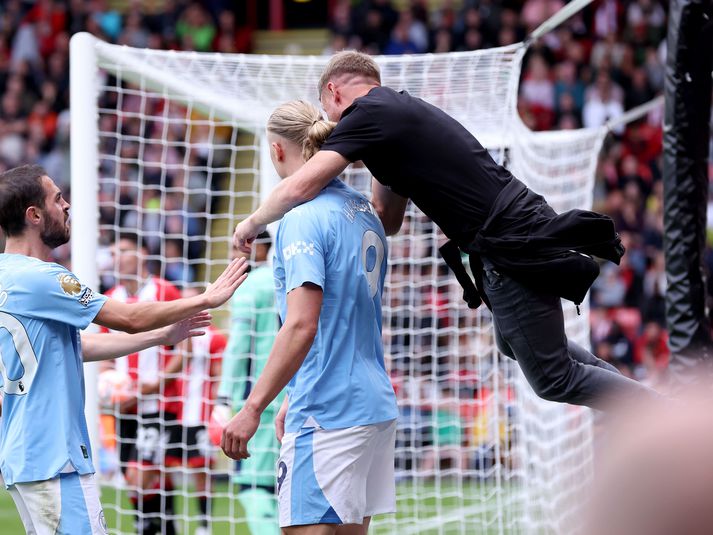 Hér sést Terry Flanagan stökkva á Haaland úr stúkunni.