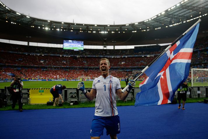 Hannes Þór Halldórsson fagnar með íslenska fánann á lofti.