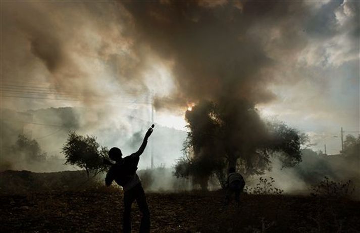 Palestínskur drengur kastar grjóti að ísraelskum hermönnum í bænum Qabatiya á Vesturbakkanum í dag.