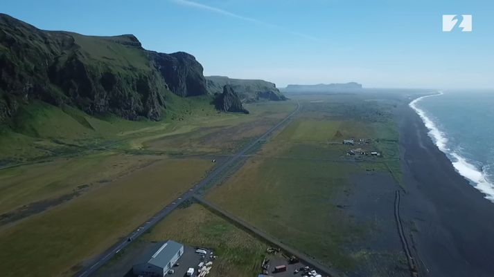 Víkurklettur sést fyrir miðri mynd en út frá honum verður varnargarðurinn lagður. Austustu húsin í Vík sjást neðst.