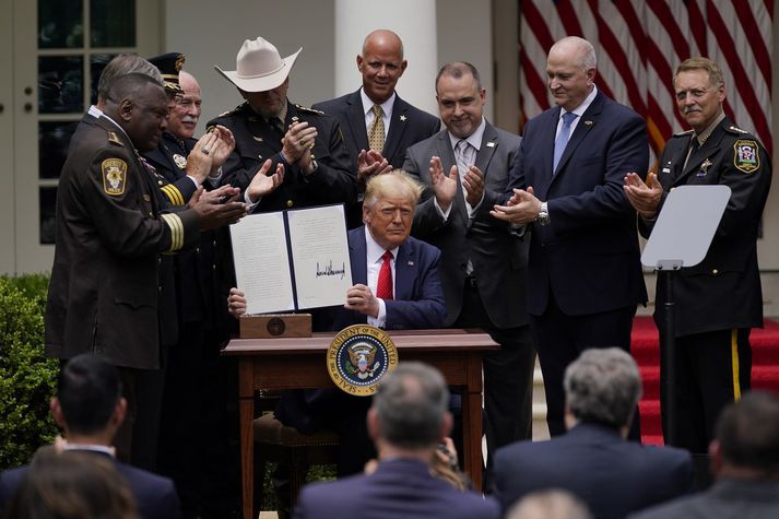 Donald Trump skrifaði undir tilskipunina umkringdur löggæsluaðilum.