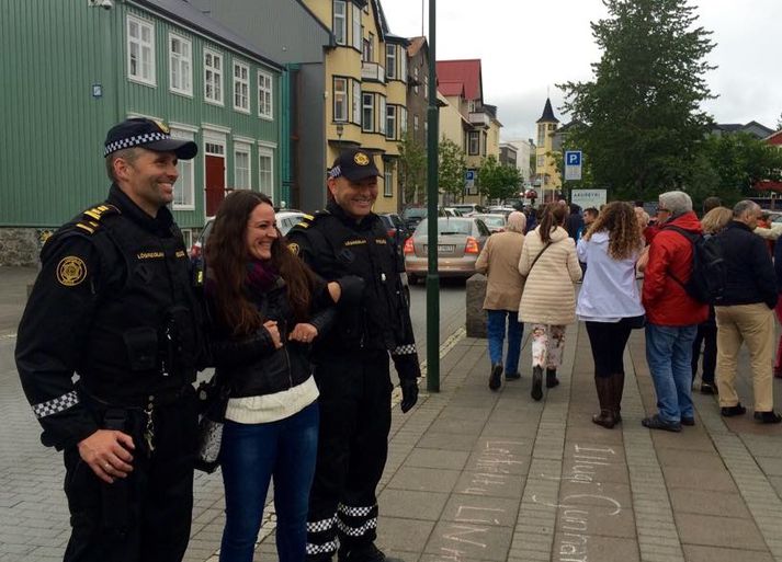 Ferðamaður fær mynd af sér með lögreglu.