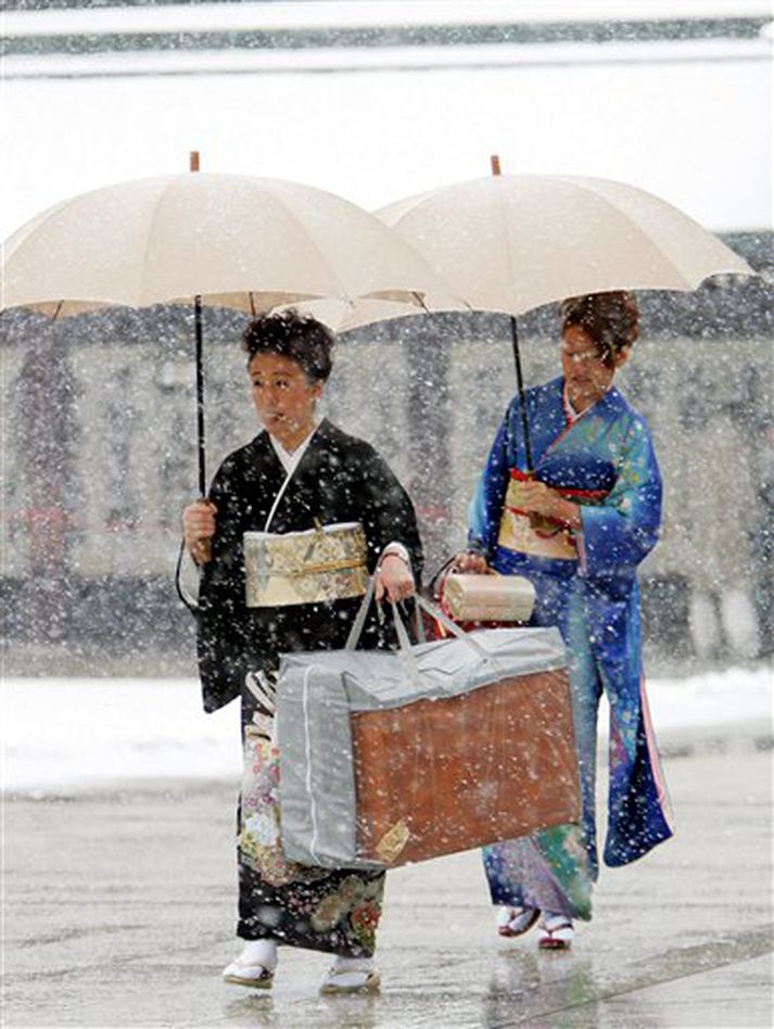 Snjóað hefur í Japan eins og þessar kimono-klæddu konur fengu að kynnast.
