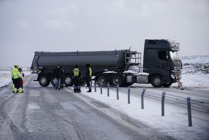 Vörubíllinn þverar veginn og hafa myndast langar biðraðir.