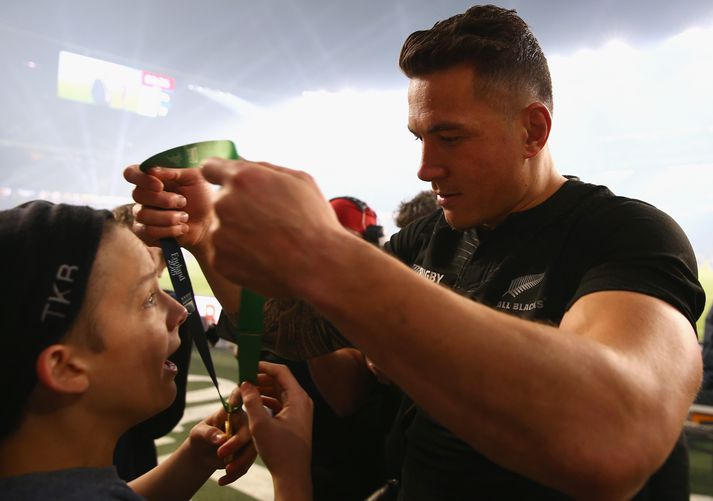 Sonny Bill Williams afhendir hér stuðningsmanninum verðlaunapeninginn.