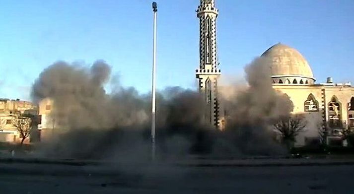 Sprengjum rignir á Homs Þykkan reyk má sjá skammt frá mosku í hverfinu Baba Amro.