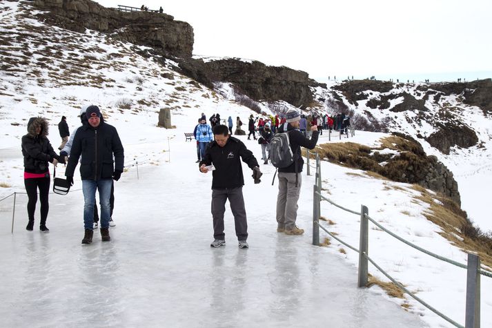 Ferðamenn fara sér að engu óðslega á svellinu sem þeim er hleypt út á við Gullfoss. 