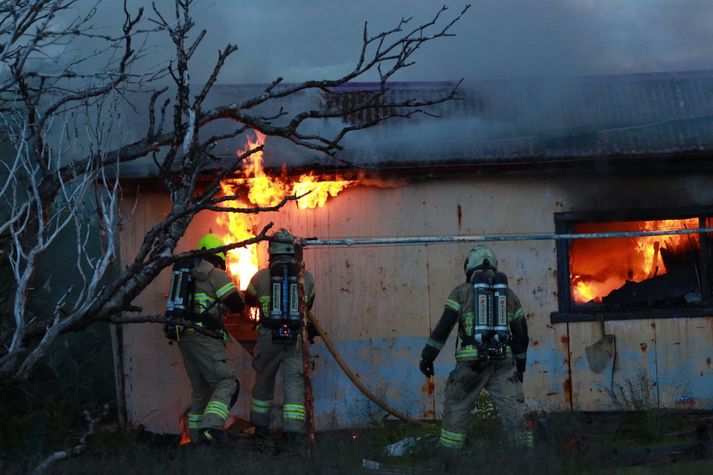 Slökkviliðið berst við eldinn sem kviknaði í skúrnum.