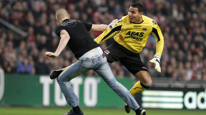 Esteban Alvarado lendir hér í stuðningsmanni Ajax.