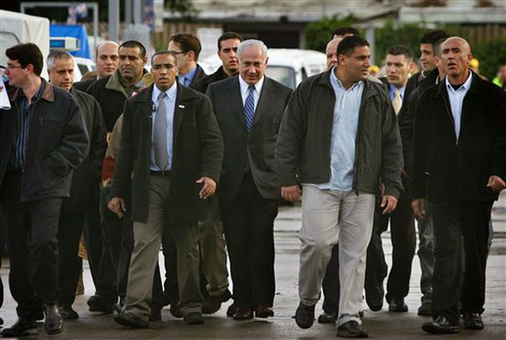 Benjamin Netanyahu, leiðtogi Likud - fyrir miðju, kemur til kjörfundar í fylgd lífvarða sinna og aðstoðarmanna.