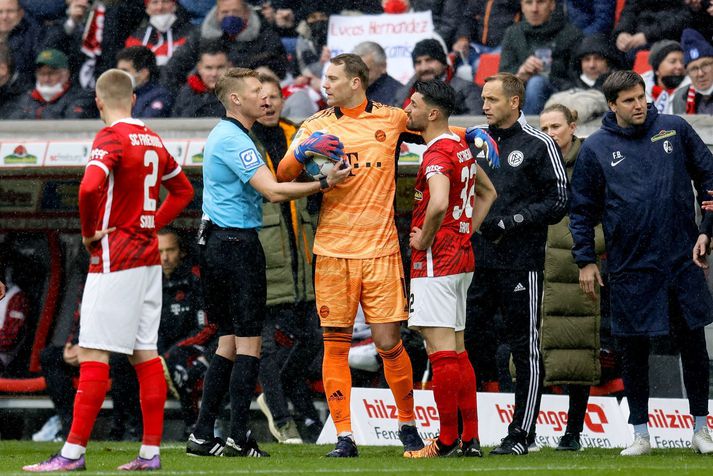 Manuel Neuer, markvörður Bayern München, sést hér ræða við dómarann eftir að  Bayern liðið var allt í einu komið með tólf menn inn á völlinn.