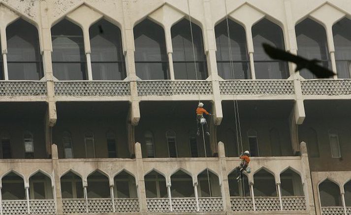 Verkamenn vinna að viðgerð utan á Taj Mahal-hótelinu í Mumbai. Það var í gær opnað á ný eftir viðgerðir eftir blóðbaðið.