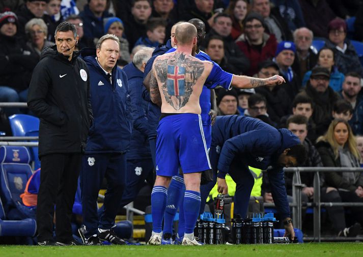 Aron Einar Gunnarsson ræðir við Neil Warnock með íslenska skjaldarmerkið á bakinu.