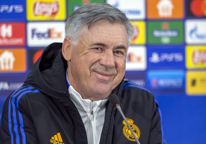 Carlo Ancelotti glottir á blaðamannafundi fyrir leik Real Madrid á móti Sheriff Tiraspol í Moldóvu.