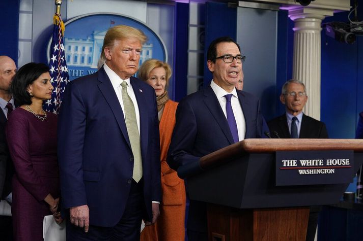 Steve Mnuchin, fjármálaráðherra, við ræðupúlt í Hvíta húsinu með Donald Trump forseta í dag. Þeir vilja að Bandaríkjaþing samþykki risavaxna efnahagslega innspýtingu á allra næstu dögum.