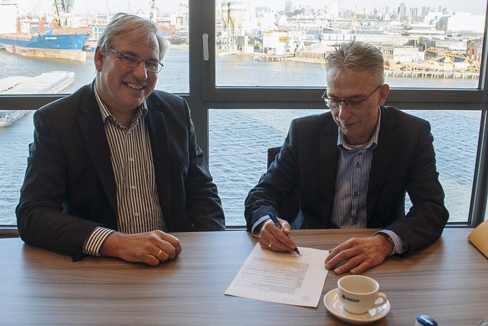 Dick Vlasblom, forstöðumaður Eimskips í Hollandi, til vinstri, og Dick Weijgertze, framkvæmdastjóri Jac. Meisner, undirrita samninginn.