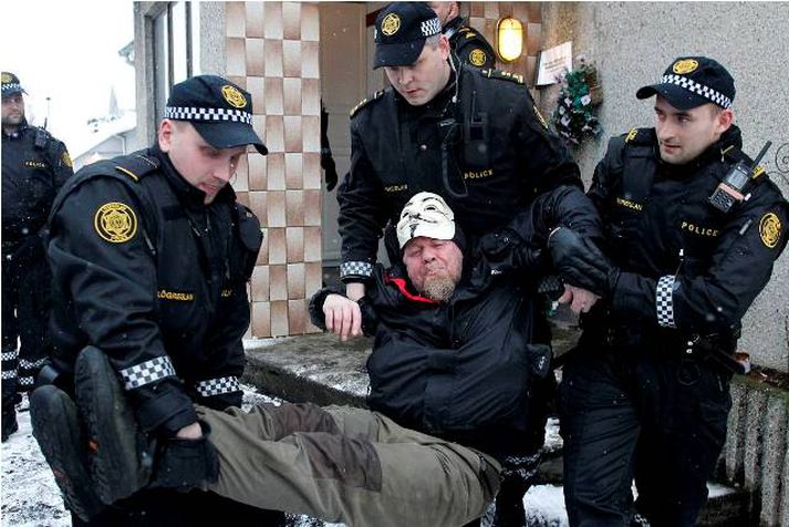 Lögreglumenn bera mann út úr húsinu að Breiðagerði.
