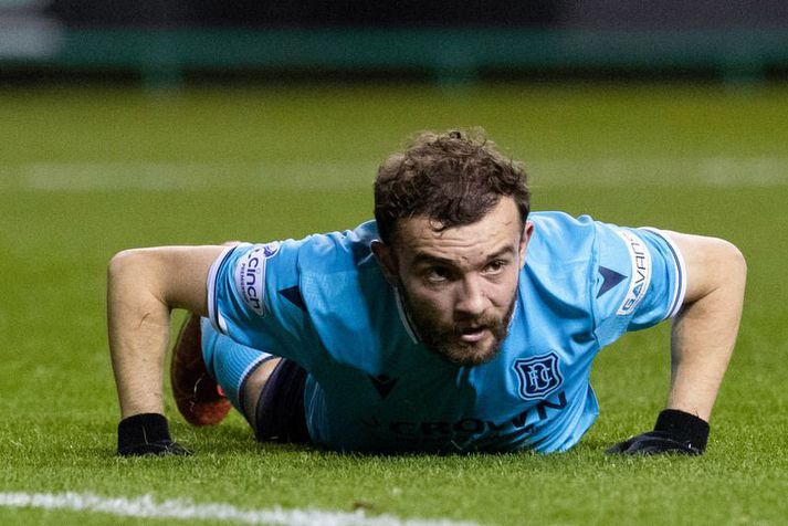 Paul McMullan liggur sársvekktur í grasinu eftir að hafa skorað í eigið mark í 1-0 sigri Hibernian á Dundee.