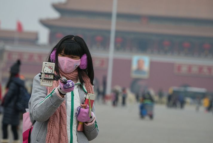 Ferðalangur með öndunargrímu á Torgi hins himneska friðar í lok janúar. Mengun í Peking-borg var mikil á köldustu dögum mánaðarins.   FRÉTTABLAÐIÐ/EPA