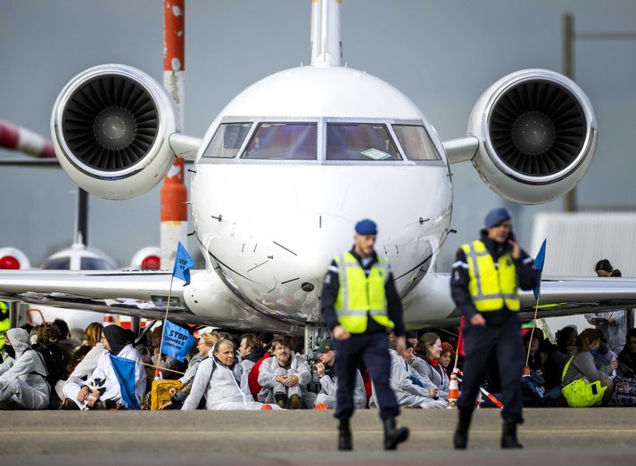 Mótmælendurnir tóku sér stöðu við dekk einkaþotnanna og komu í veg fyrir að hægt væri að hreyfa þær á Schiphol-flugvelli í gær. 