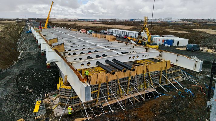 Vegagerðin segir að vel gangi með að tengja bita í Ölfusárbrú. Vegfarendur sitja hins vegar fastir í bílalest og komast hvergi.