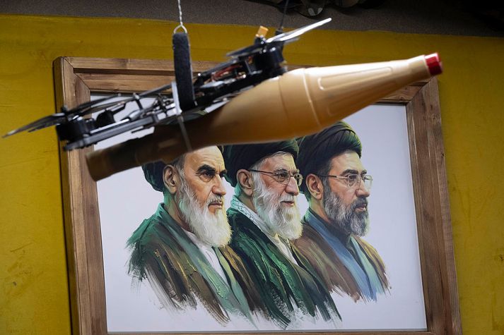 Dróna er hér stillt upp fyrir framan plakat af fyrrverandi æðstuklerkunum Ayatollah Ruhollah Khameini og Ayatollah Ali Khamenei, Ayatollah Mojtaba Khamenei.