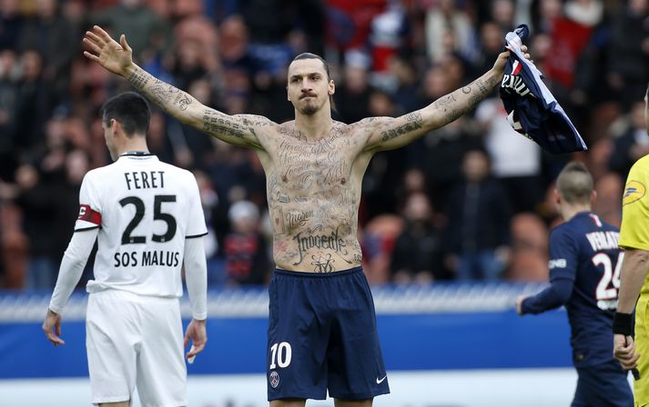 Zlatan sýnir áhorfendum húðflúrin.