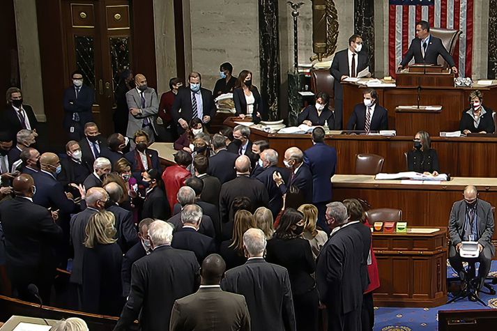 Nancy Pelosi, forseti fulltrúadeildarinnar, fagnar hér með félögum sínum á gólfi þingsalarins eftir að málið var í höfn í nótt.