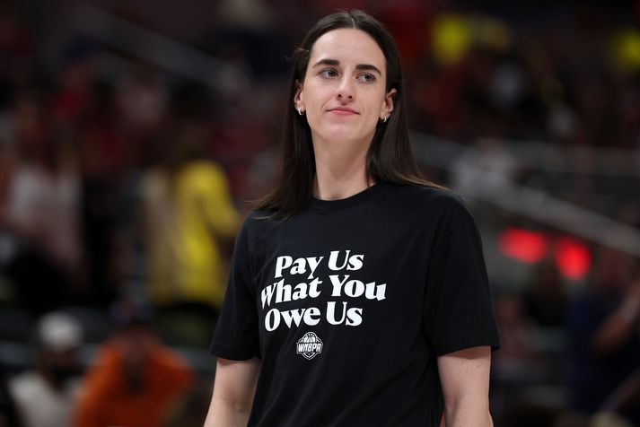 Caitlin Clark í bolnum sem á stóð „Pay Us What You Owe Us“ eða „Borgið okkur það sem þið skuldið okkur“.
