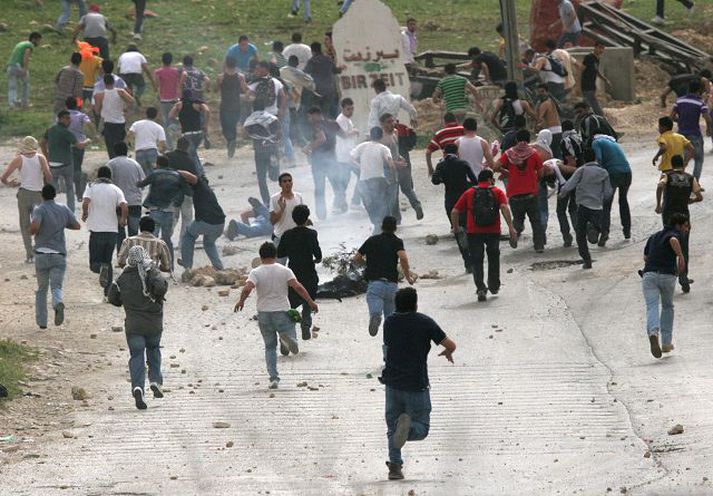 Átök við Ramallah Hópur Palestínumanna á hlaupum eftir átök við ísraelska hermenn norðan við Ramallah.fréttablaðið/AP