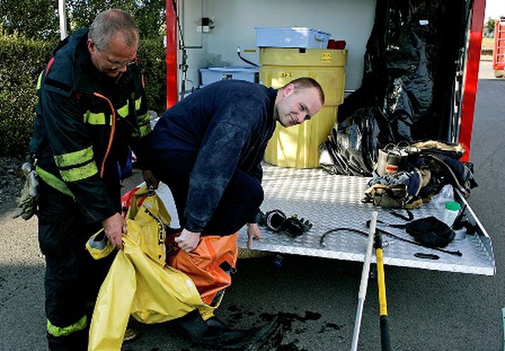 Tæknimenn slökkviliðsins smeygja sér úr búningum á vettvangi.