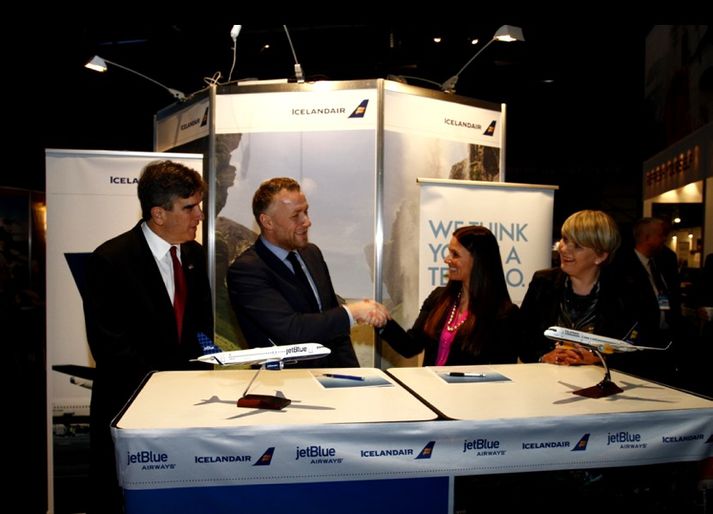 Birkir Hólm Guðnason framkvæmdastjóri Icelandair Group og Tracy Lynn Bink, framkvæmdastjóri samstarfs- og samvinnu við flugfélög hjá JetBlue, handsala samkomulag félaganna. Með þeim eru Robert C. Barber, sendiherra Bandaríkjanna á Íslandi og Ragneiður Elín Árnadóttir ráðherra ferðamála.