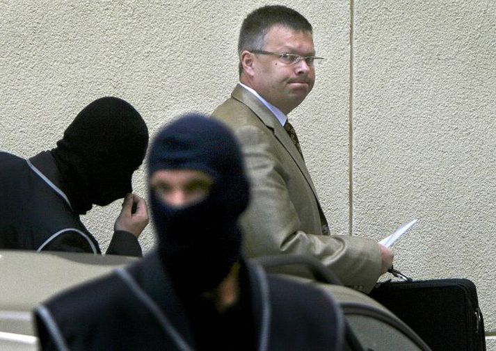 Handtekinn Janusz Kaczmarek í fylgd sérsveitarlögreglumanna í Varsjá.