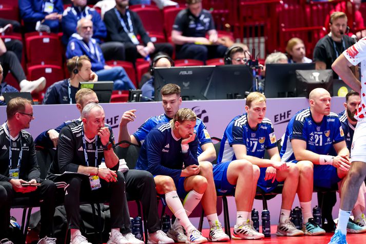 Einar Þorsteinn og aðrir leikmenn og starfsmenn íslenska liðsins niðurlútir á bekknum.