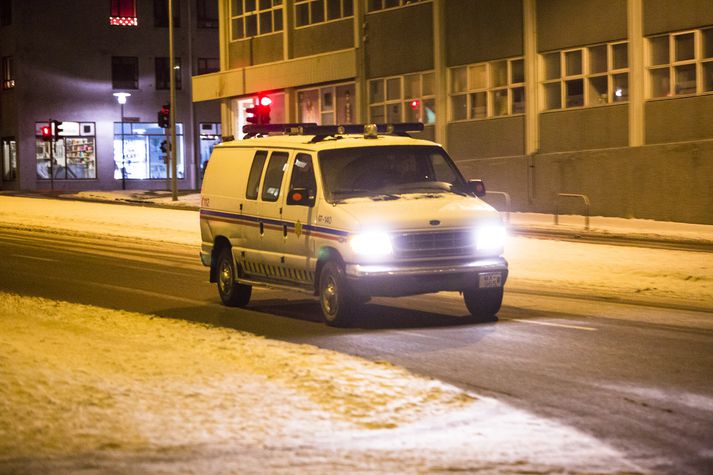 Lögreglubifreið nálgast lögreglustöðina á Hverfisgötu.